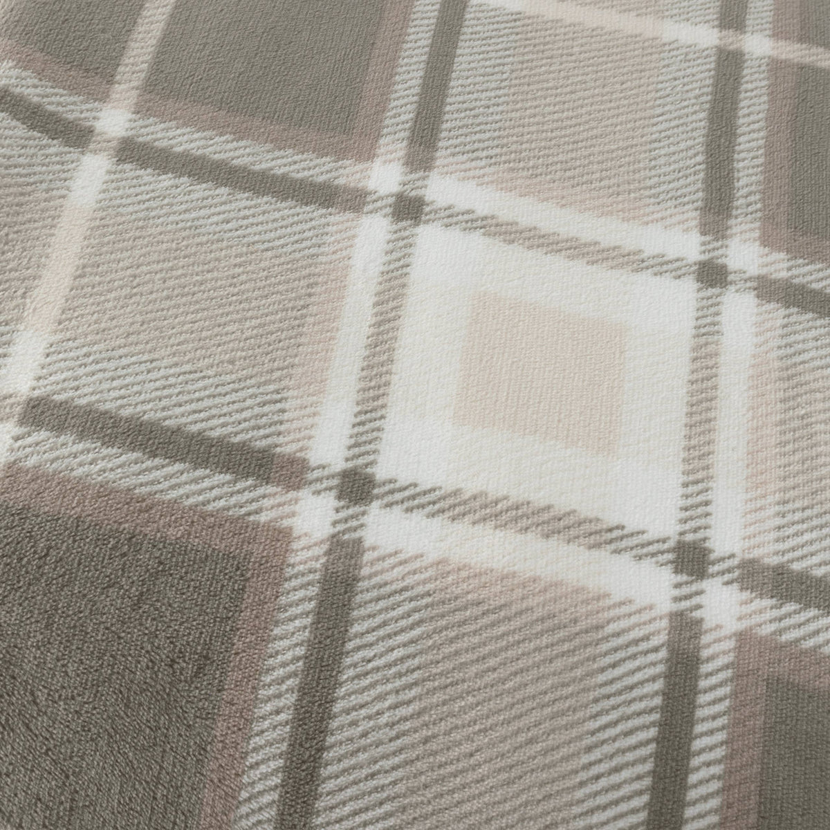 Riva Home Braemar check sherpa fleece throw in green and natural tones draped over a sofa