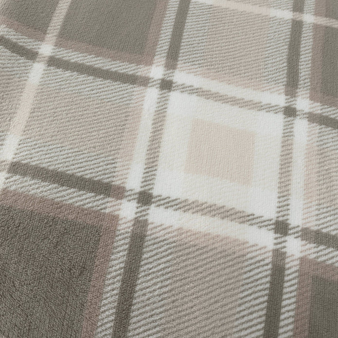 Riva Home Braemar check sherpa fleece throw in green and natural tones draped over a sofa
