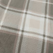 Riva Home Braemar check sherpa fleece throw in green and natural tones draped over a sofa