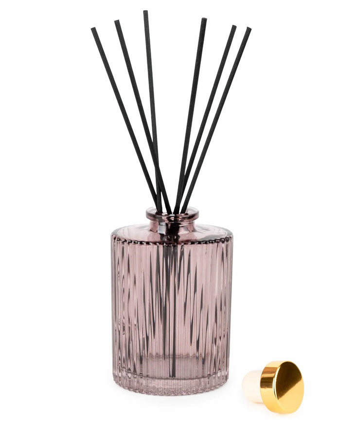Diffuser bottle with black sticks and gold cap on a white background
