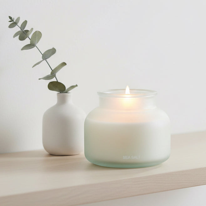 Frosted blue large sea salt scented candle from Candlelight Products Ltd, with a smooth, rounded wax surface and wavy flame.