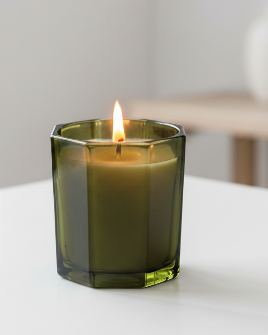 Olive green octagonal candle from Candlelight Products Ltd, featuring a smooth candle with a geometric shape and warm glow.