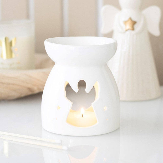 Angel cut-out oil burner and wax warmer from Something Different Wholesale, showcasing a decorative ceramic design with a lit tealight.