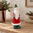 Large Red Ceramic Santa Holding a Present styled in a warm neutral Christmas interior