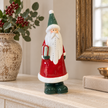 Large Red Ceramic Santa Holding a Present styled in a warm neutral Christmas interior