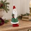 Large Green Ceramic Santa Holding a Present styled in a warm neutral Christmas interior