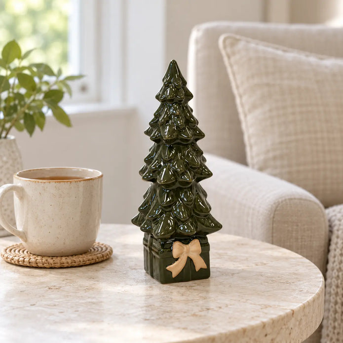 Green ceramic tree on present-shaped base beside a mug of tea for scale.