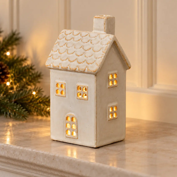 Christmas ceramic house tealight holder by Satchville with a warm glowing light, perfect for holiday decor.