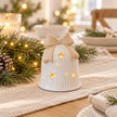 Light-up ceramic Christmas bell styled on a linen dining table