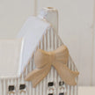Close-up of ceramic natural bow and ribbed wall details on white Christmas tealight house