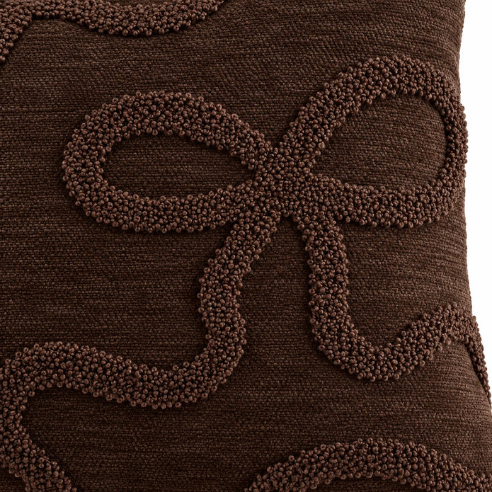 Close-up of raised chocolate brown bouclé bow outline and woven cushion cover fabric
