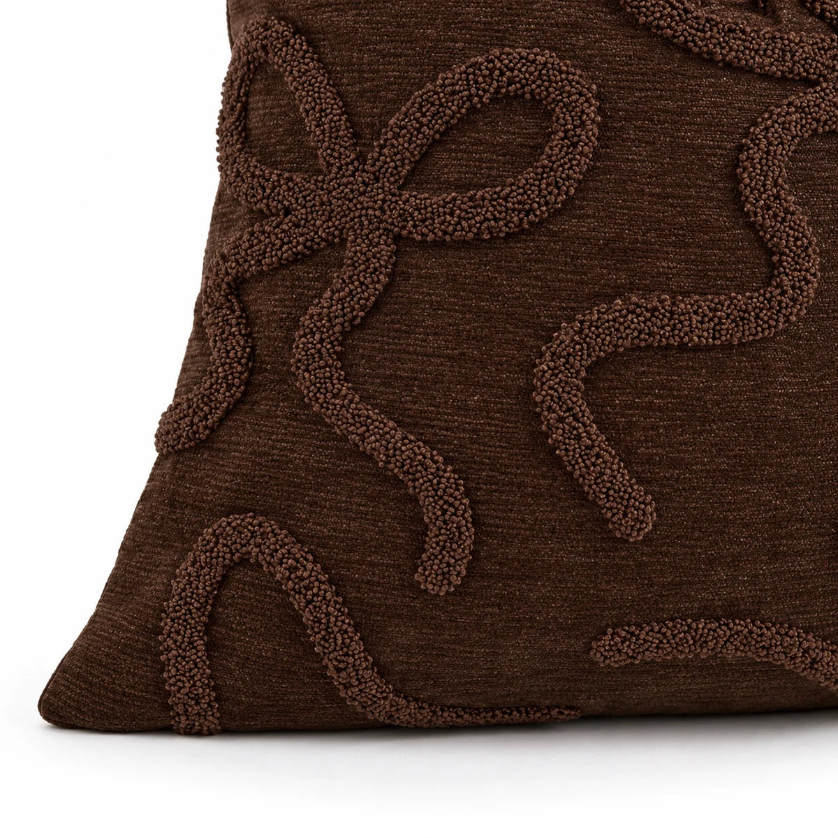 Close-up of the chocolate brown cushion cover corner seam and raised bow texture