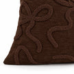 Close-up of the chocolate brown cushion cover corner seam and raised bow texture