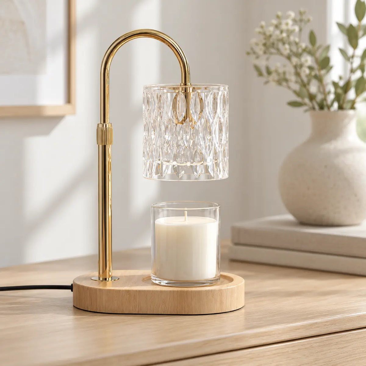 Clear glass candle warmer switched off on a pale oak dresser