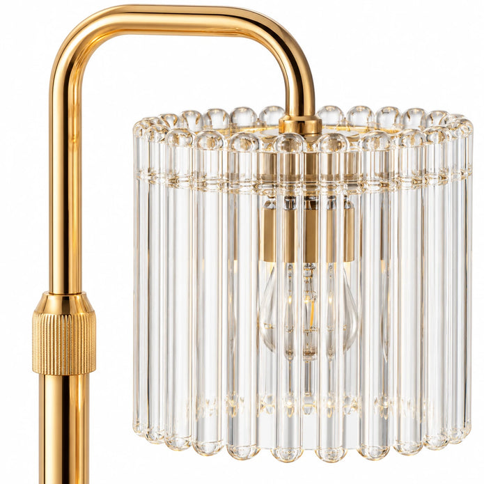 Close-up of the clear ribbed glass shade and gold-tone arm of the candle warmer lamp