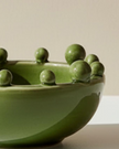 Small olive green Coach House bobble-edged bowl, decorative home decor piece with textured edge and smooth interior.