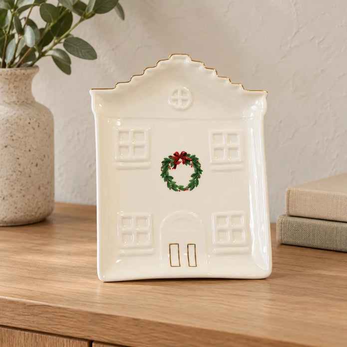 Ivory Cosy Christmas House Plate with painted wreath displayed on an oak console.