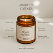 Sweet Water Decor amber 9 oz candle feature graphic, illustrated with a lit Warm and Cozy candle.