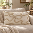 Cream and beige bow rectangle bouclé cushion cover styled on an oatmeal sofa in a neutral country living room.