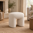 Cream boucle arched footstool styled in a warm neutral living room