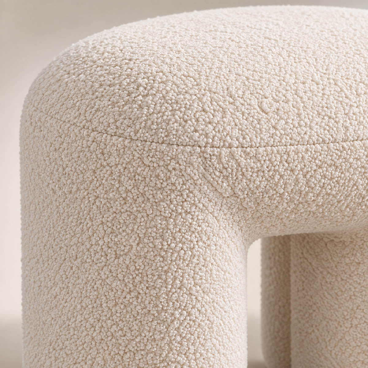 Close-up of cream boucle fabric and curved footstool seam