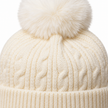 Close-up of cream cable knit hat and faux-fur pom pom texture