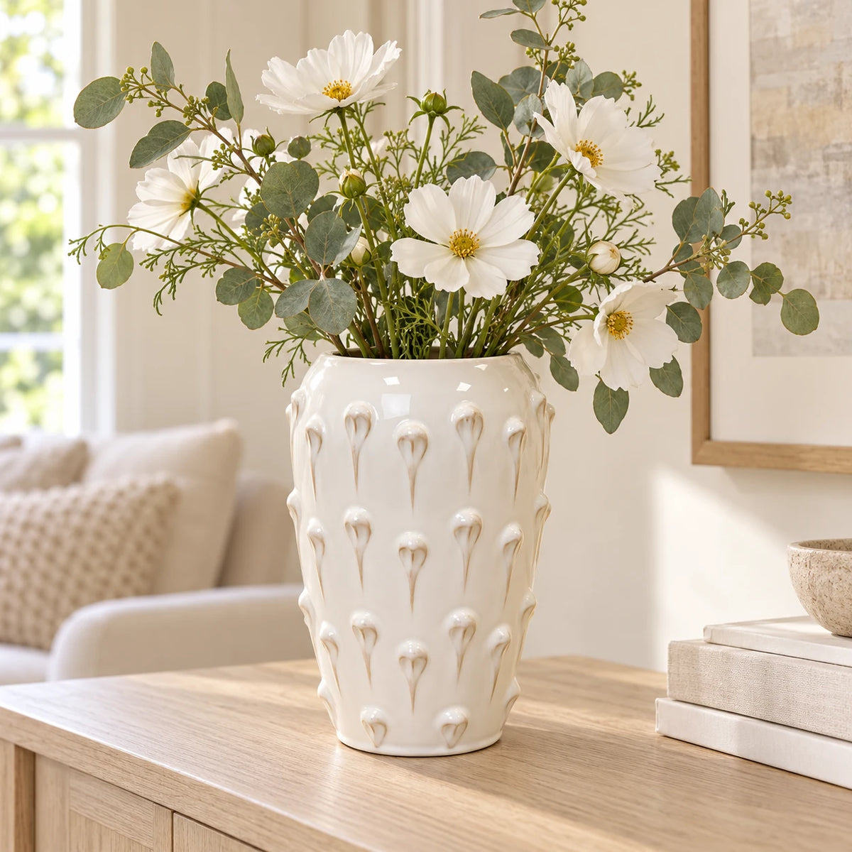 large ivory cream ceramic bobble vase with white flowers on a pale oak console
