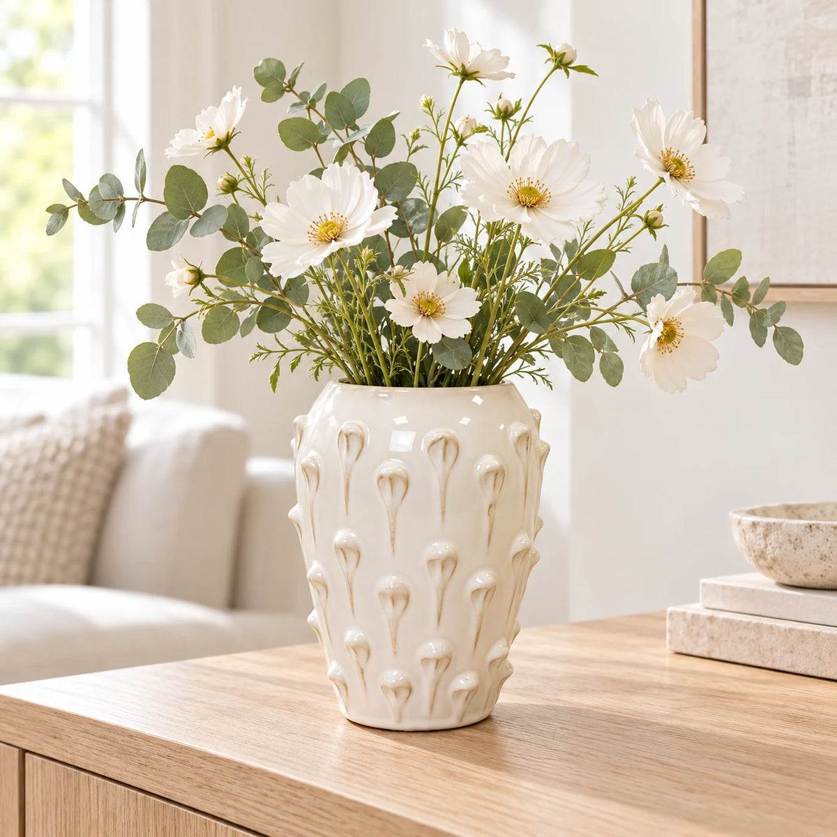 medium ivory cream ceramic bobble vase with white flowers on a pale oak console