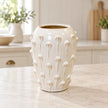 medium ivory cream ceramic bobble vase on a pale stone counter in a bright cream kitchen