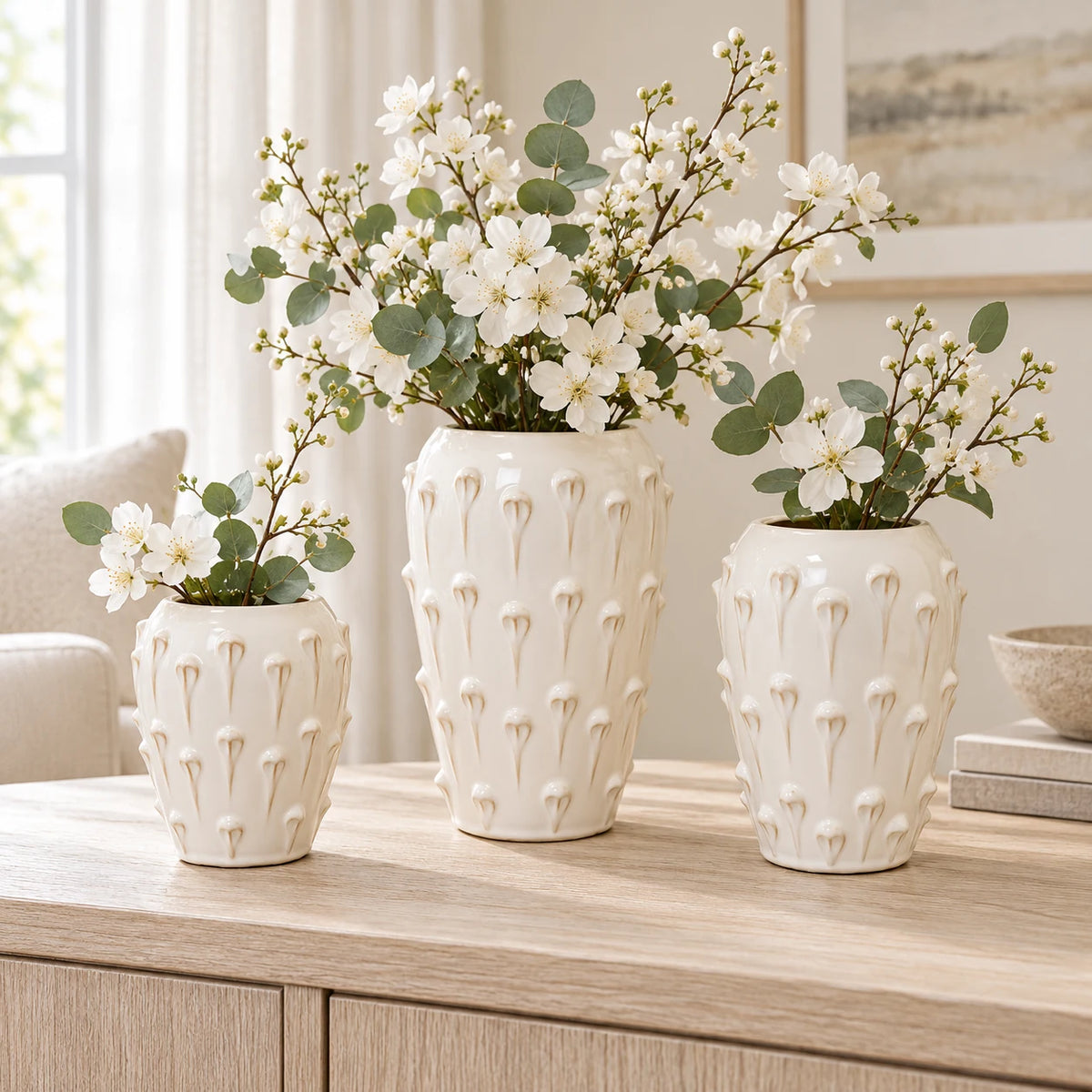 Small, medium and large ivory cream ceramic bobble vases with white flowers, shown together for size comparison; each sold separately