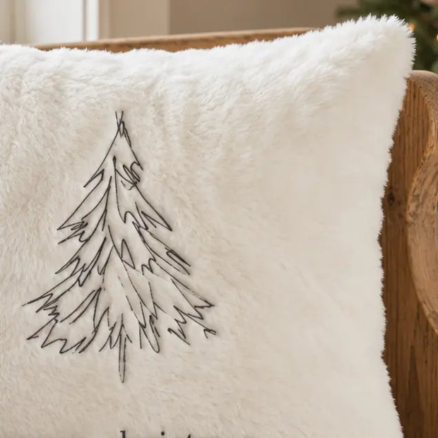 Close-up of the black embroidered Christmas tree on the cream fluffy cushion cover