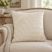 Cream Fern Embroidered Cushion Cover styled on a cream wooden armchair beside a neutral knitted throw.