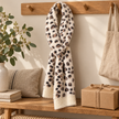 Cream leopard pull-through scarf styled on an oak peg rail