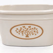 Close-up of the raised warm taupe tree and heart-leaf medallion on the cream planter.