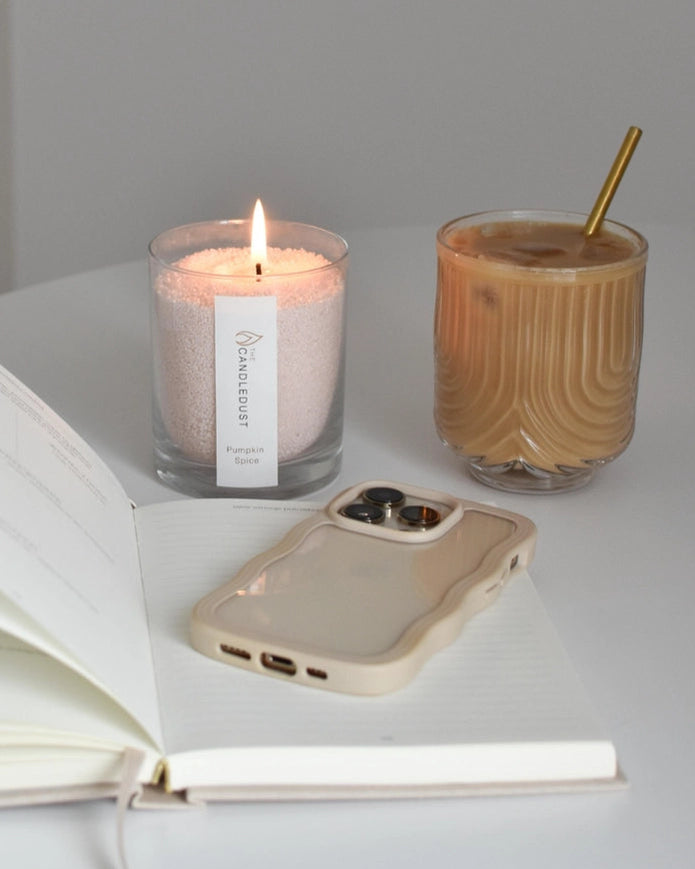 White scented candle in a clear sand jar with dark honey scent, part of The Candledust home fragrance collection.