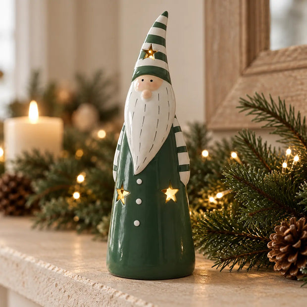 Dark green and white LED ceramic gonk glowing among Christmas greenery