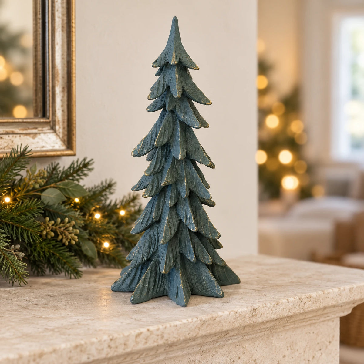 Tall dark sage gold-edged resin tree on a limestone Christmas mantel.