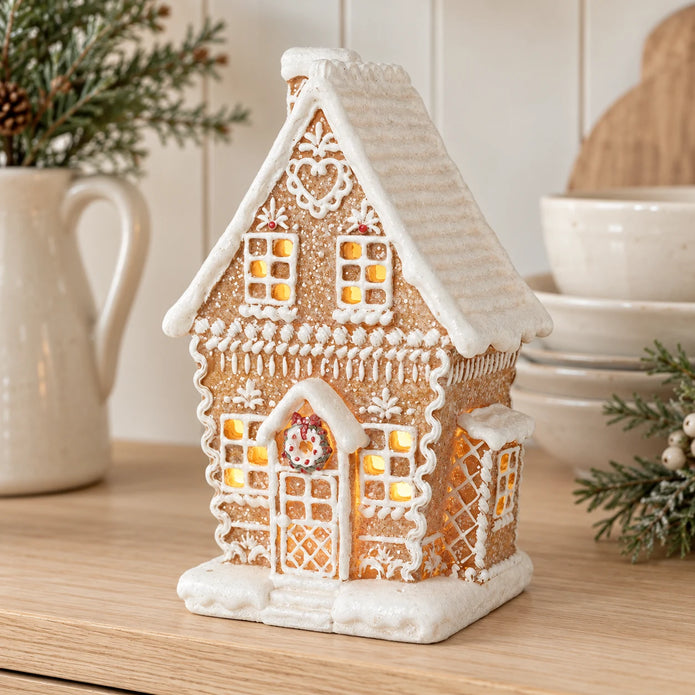 Decorated gingerbread house displayed on a pale oak kitchen dresser