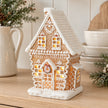 Decorated gingerbread house displayed on a pale oak kitchen dresser