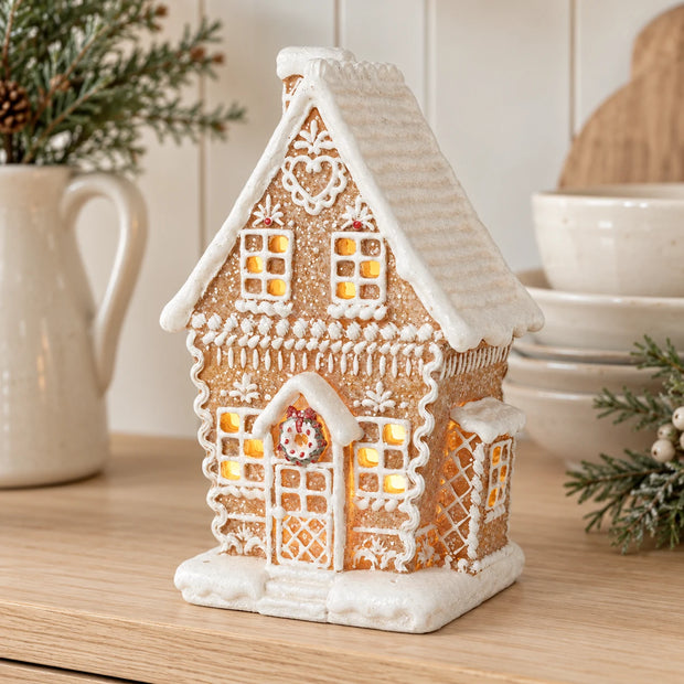Decorated gingerbread house displayed on a pale oak kitchen dresser