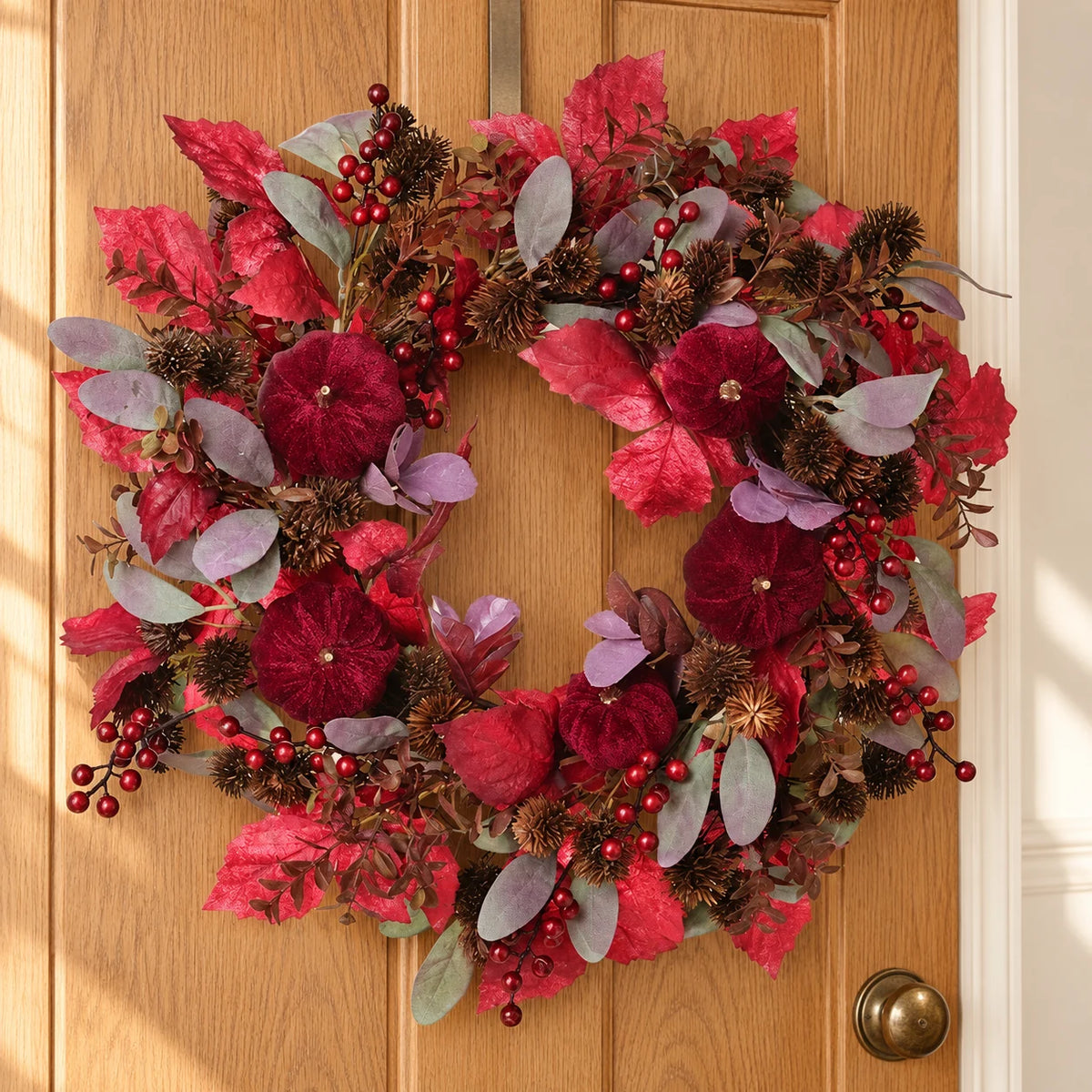 Deep red foliage and pumpkin Christmas wreath by Heaven Sends, styled for holiday decor with autumnal accents.