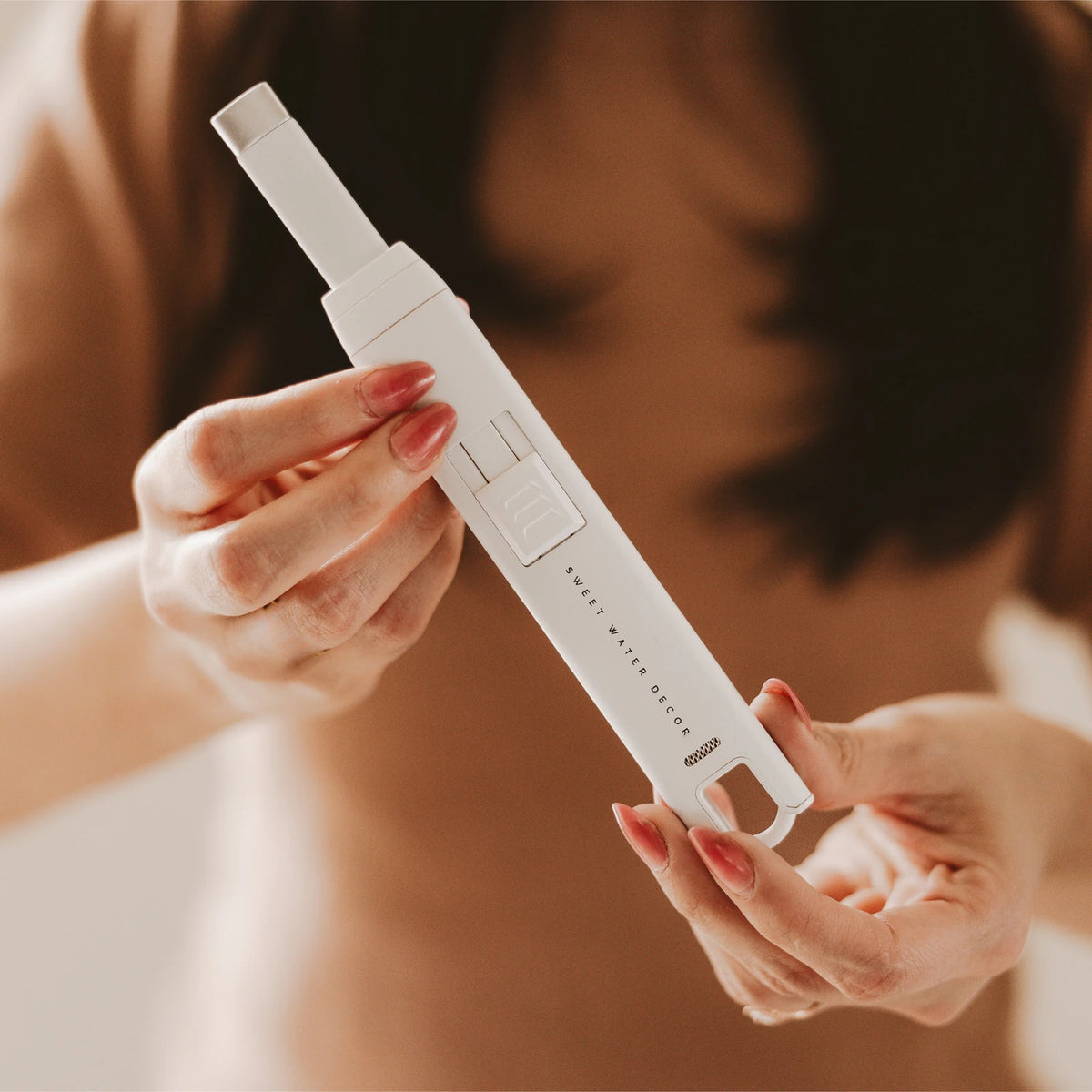 Electric Rechargeable Candle Lighter - White, hands holding the white lighter with its tip extended