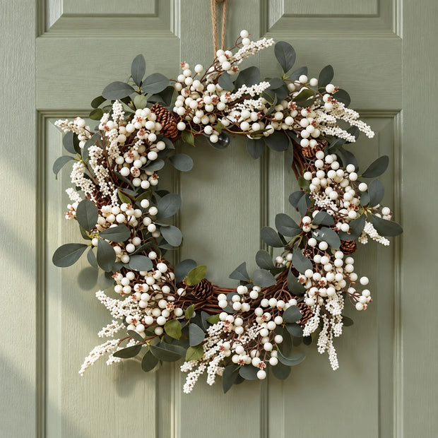 White berry and foliage wreath on a sage green door