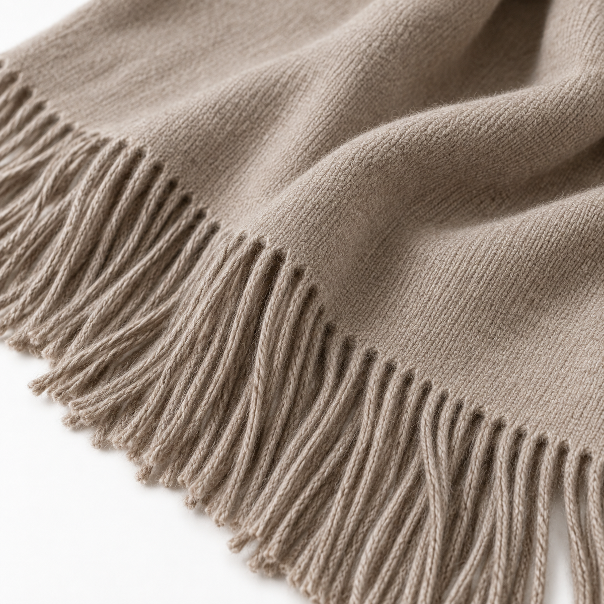 Ellenvale Trade beige and brown fine knit tasseled throw blanket laid out on a sofa for cozy home decor.