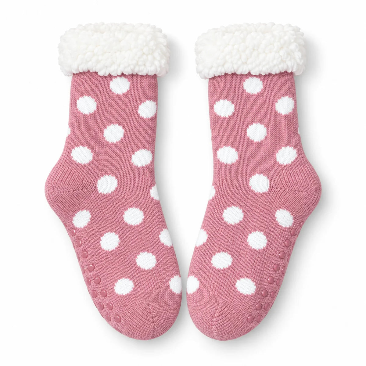 Pair of pink and white spot fleece-lined slipper socks on white