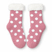 Pair of pink and white spot fleece-lined slipper socks on white