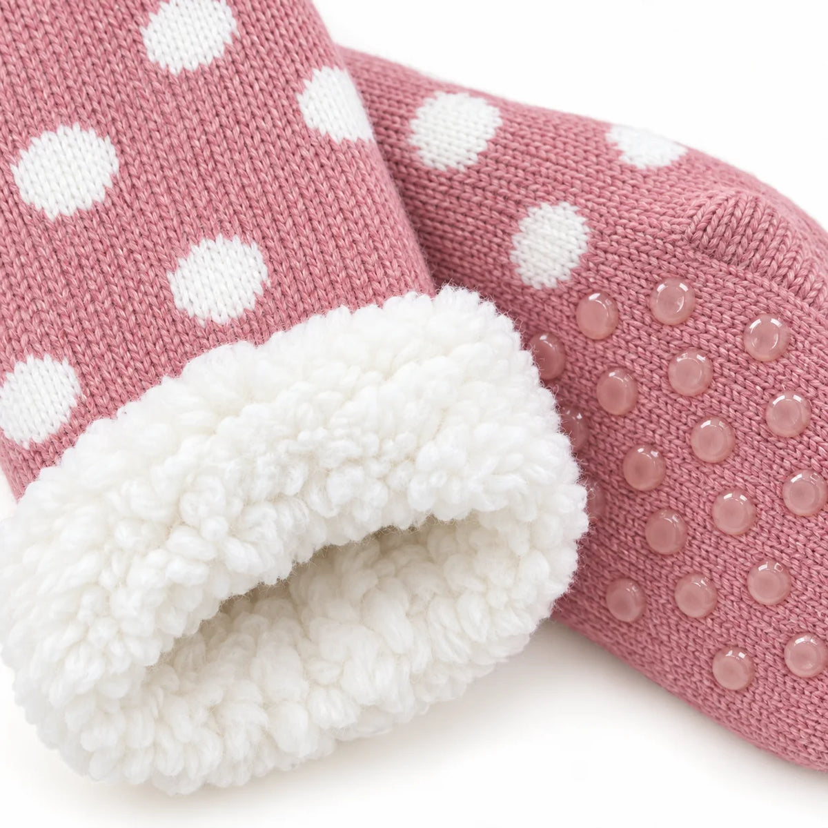 Close-up of pink spotted slipper sock knit, fleece lining and grip sole