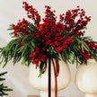 Burgundy gypsophila stems mixed with evergreen foliage in a cream footed vase.