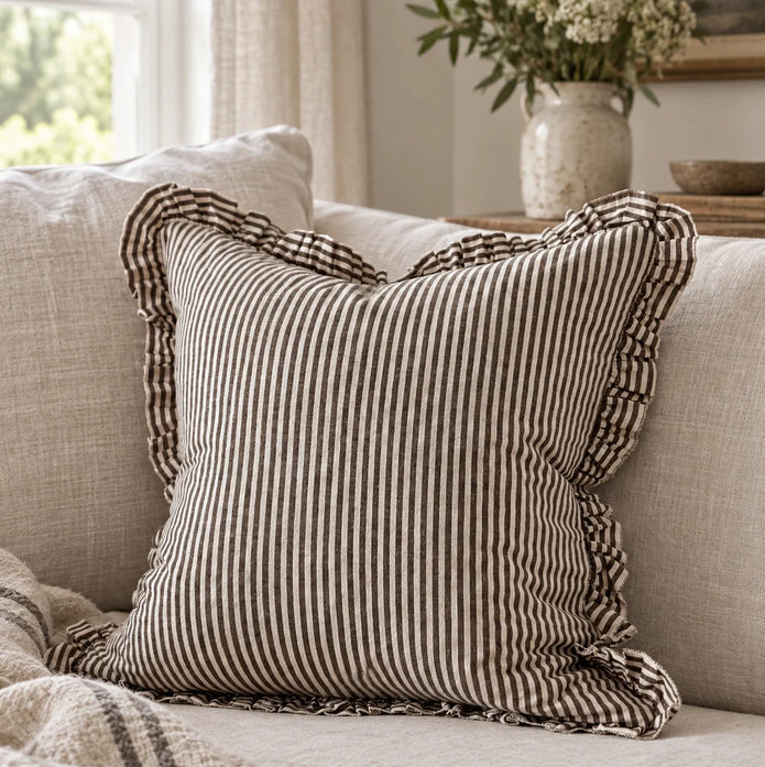 Darcy chocolate brown and white pinstripe 45cm cushion cover styled on a neutral sofa
