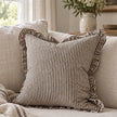 Darcy chocolate brown and white pinstripe 45cm cushion cover styled on a neutral sofa